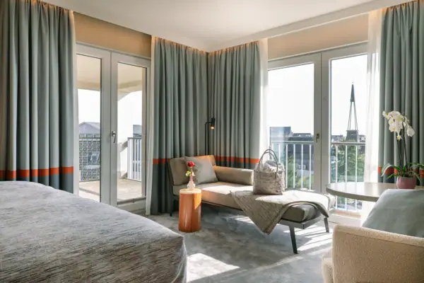 Zimmer A-ROSA Sylt Ein lichtdurchflutetes Hotelzimmer mit einem Sofa und einem Tisch.