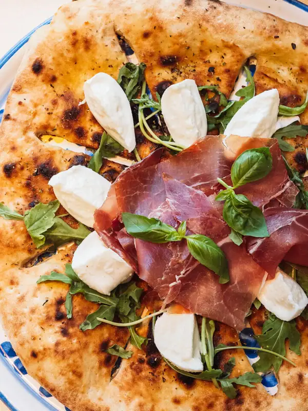 Pizza mit Fleisch und Käse auf einem Teller
