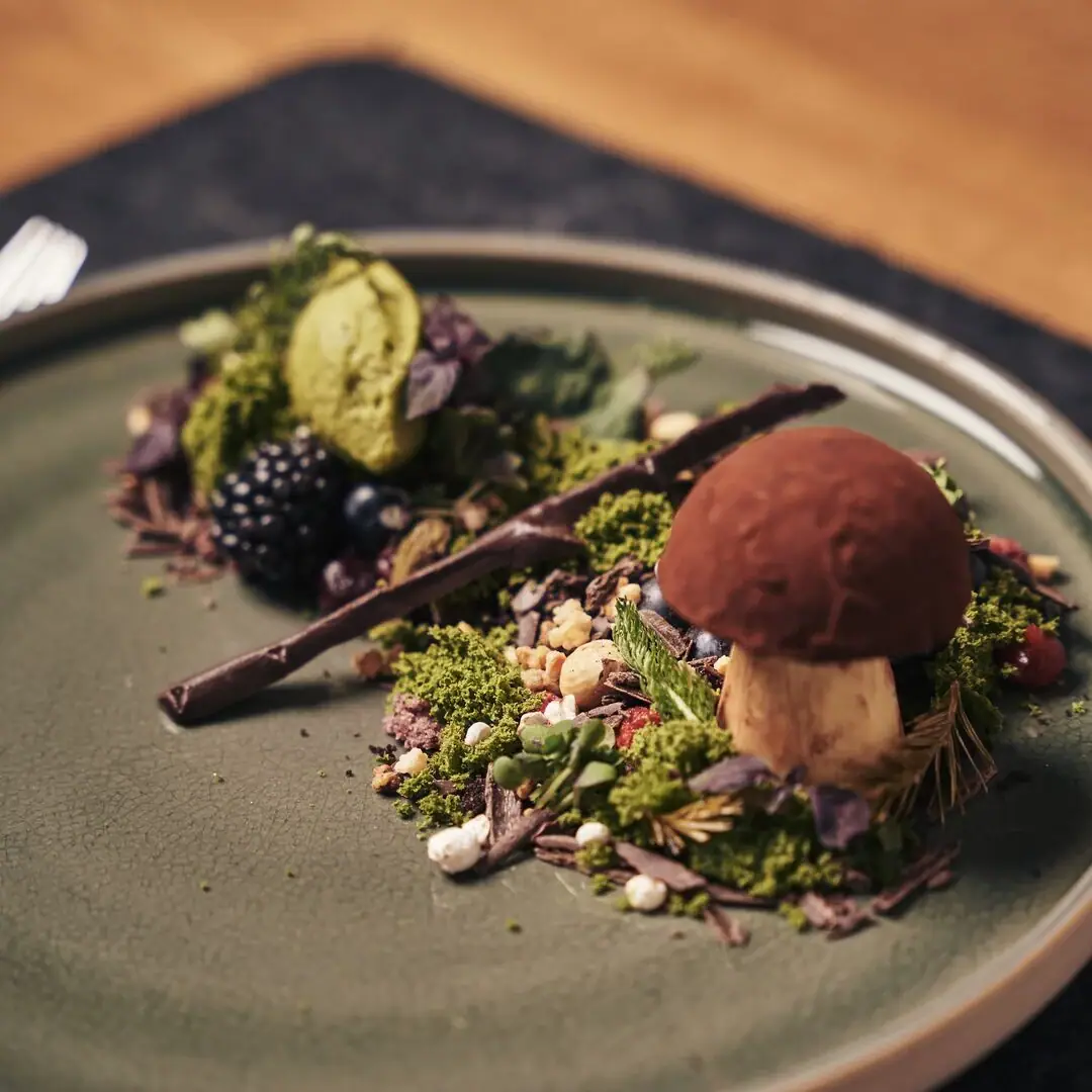 Gothisches Haus Wernigerode Ein Teller mit kunstvoll angerichteter Speise auf einem Tisch.