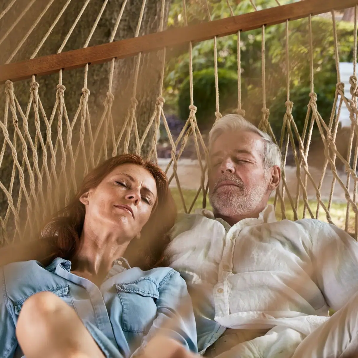 Ein Mann und eine Frau schlafen in einer Hängematte.