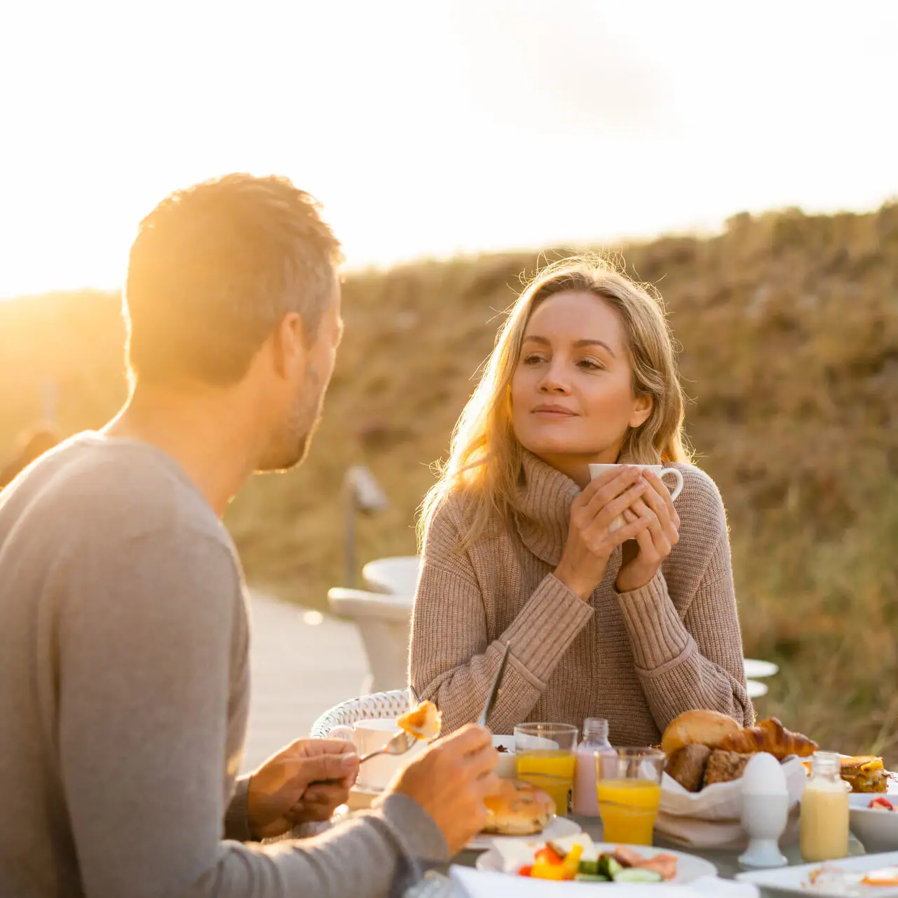 A-ROSA Sylt Ein Mann und eine Frau sitzen an einem Tisch mit Essen.