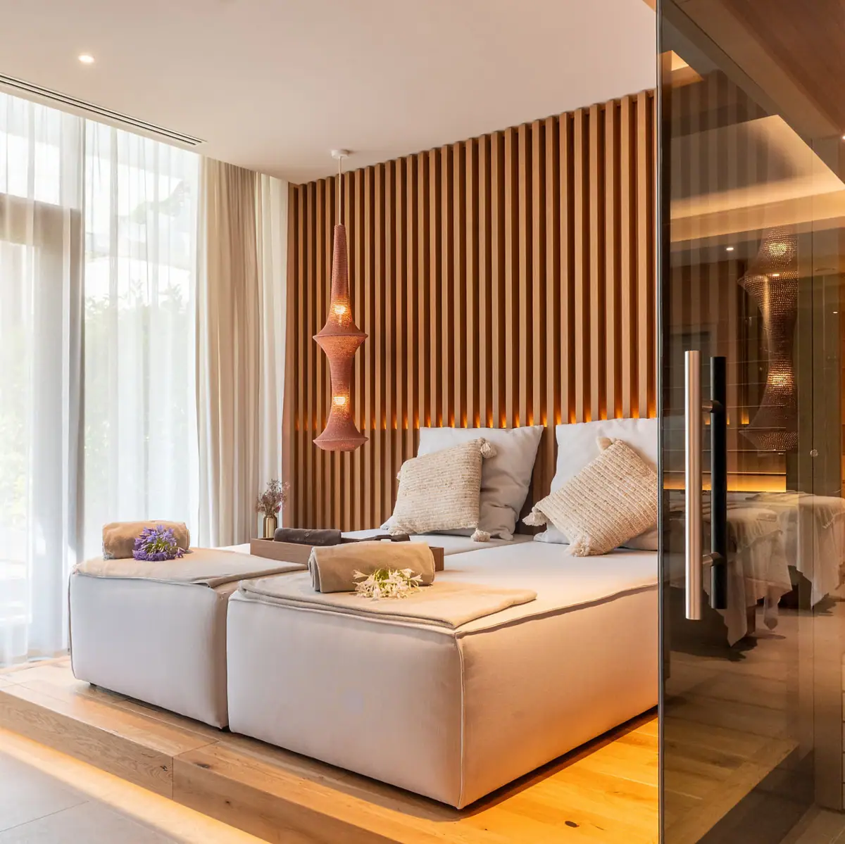 Ein Zimmer mit einem Bett und einer Glastür.