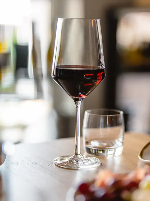 Ein Glas Wein auf einem Tisch.