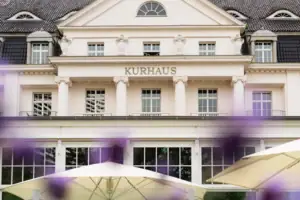 A-ROSA Travemünde Ein Gebäude mit einem großen Fenster und einem großen Sonnenschirm.