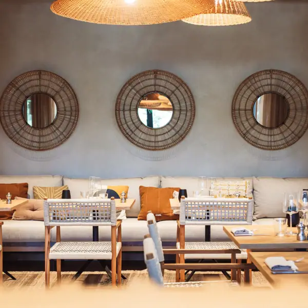 Ein Zimmer mit Couch, Tischen und Stühlen.