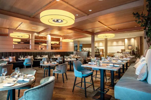 Theos Restaurant Ein Restaurant mit Tischen und Stühlen.