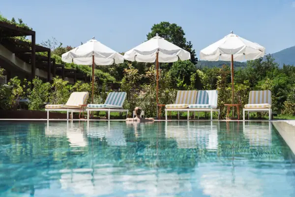 Poolbereich des SPA-ROSA im A-ROSA Gardasee Außenpool im SPA-ROSA des A-ROSA Gardasee mit Liegen und Sonnenschirmen im Gartenbereich.