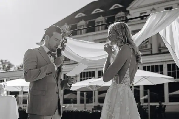 Ein Mann und eine Frau stehen nebeneinander, die Frau trägt ein Hochzeitskleid.