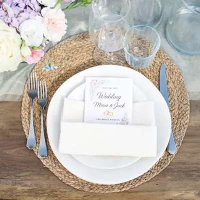 Kulinarik im A-ROSA Gardasee Tischgedeck mit Blumen und Gläsern und dem Menü des Abends.