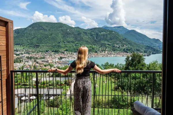 Terrasse Eine Frau steht auf einem Balkon und blickt auf eine Stadt.