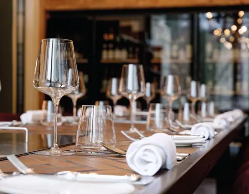 Im Weinkeller wird jedes Event ein Highlight Ein eingedeckter Tisch mit weißen Servietten, Weingläsern und Besteck