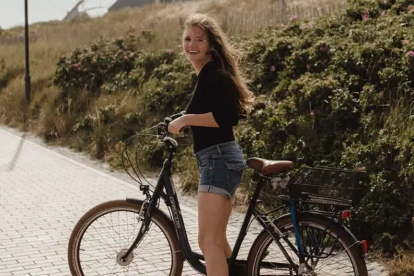 Fahrradtour Eine Frau lächelt auf einem Fahrrad.