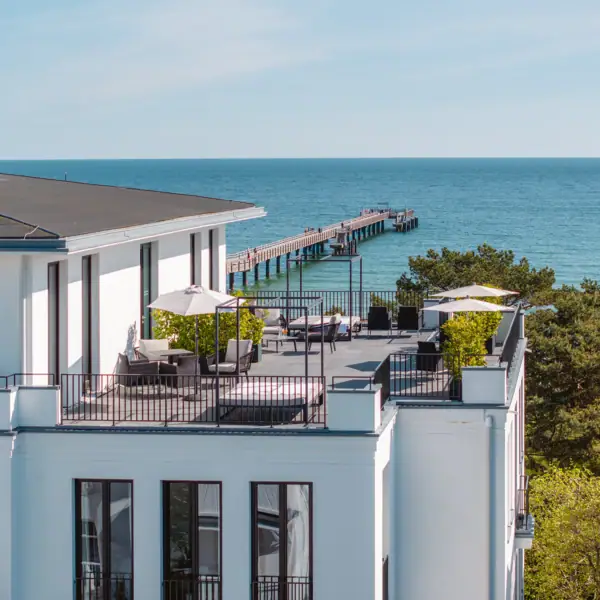 Ein Gebäude mit einem Steg und Bäumen.