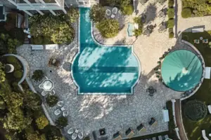 Außenbereich von oben Schwimmbecken im Garten mit Bäumen im Hintergrund.