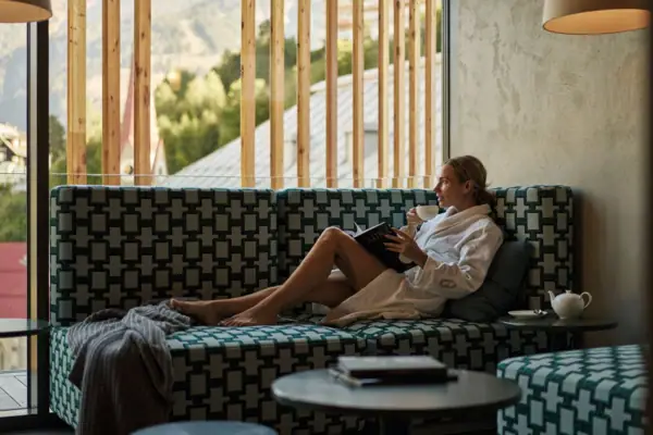 Eine Frau im Bademantel liest ein Buch.