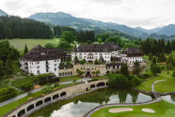 Schlosshotel Kitzbühel Das Schlosshotel Kitzbühel mit einem Teich und einem Golfplatz davor.