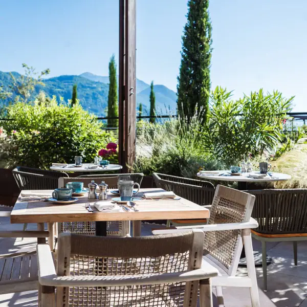 Ein Tisch und Stühle im Freien mit Bergen im Hintergrund.