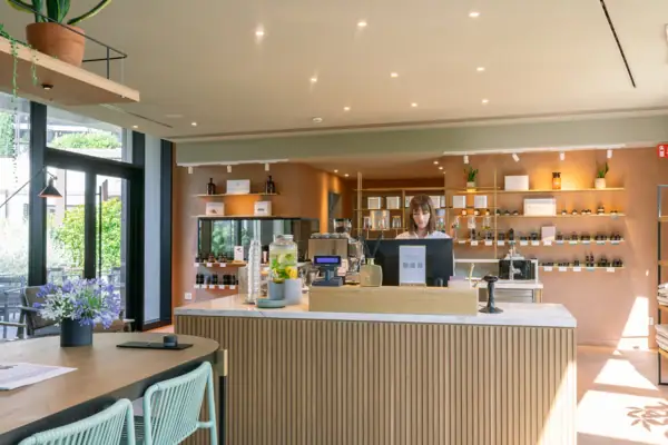 SPA-ROSA Shop am Gardasee Eine Frau hinter einem Tresen des SPA-ROSA Shops mit Kosmetikprodukten und Accessoires im A-ROSA Gardasee.