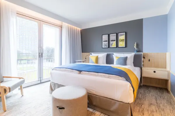 Zimmer Ein Bett in einem Hotelzimmer mit eleganter Bettwäsche und Kissen.