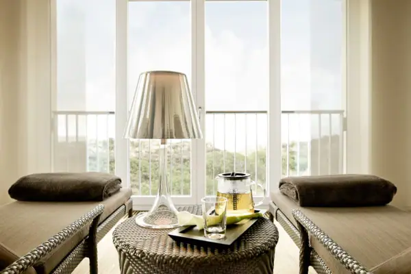 Ein Tisch mit einer Lampe und einem Glas darauf.