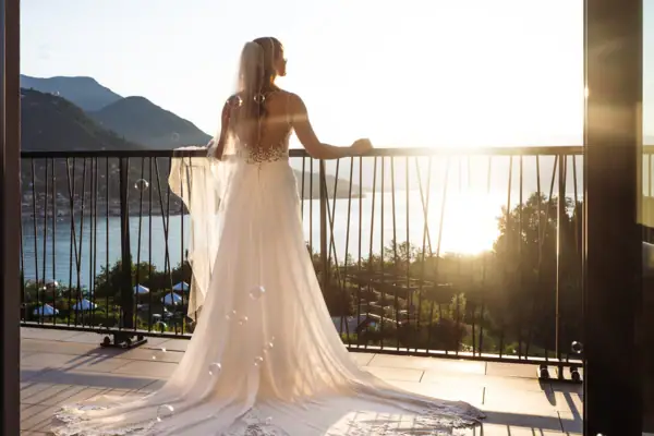 Braut auf dem Balkon ihres Zimmers im A-ROSA Gardasee Eine Frau in einem Hochzeitskleid.