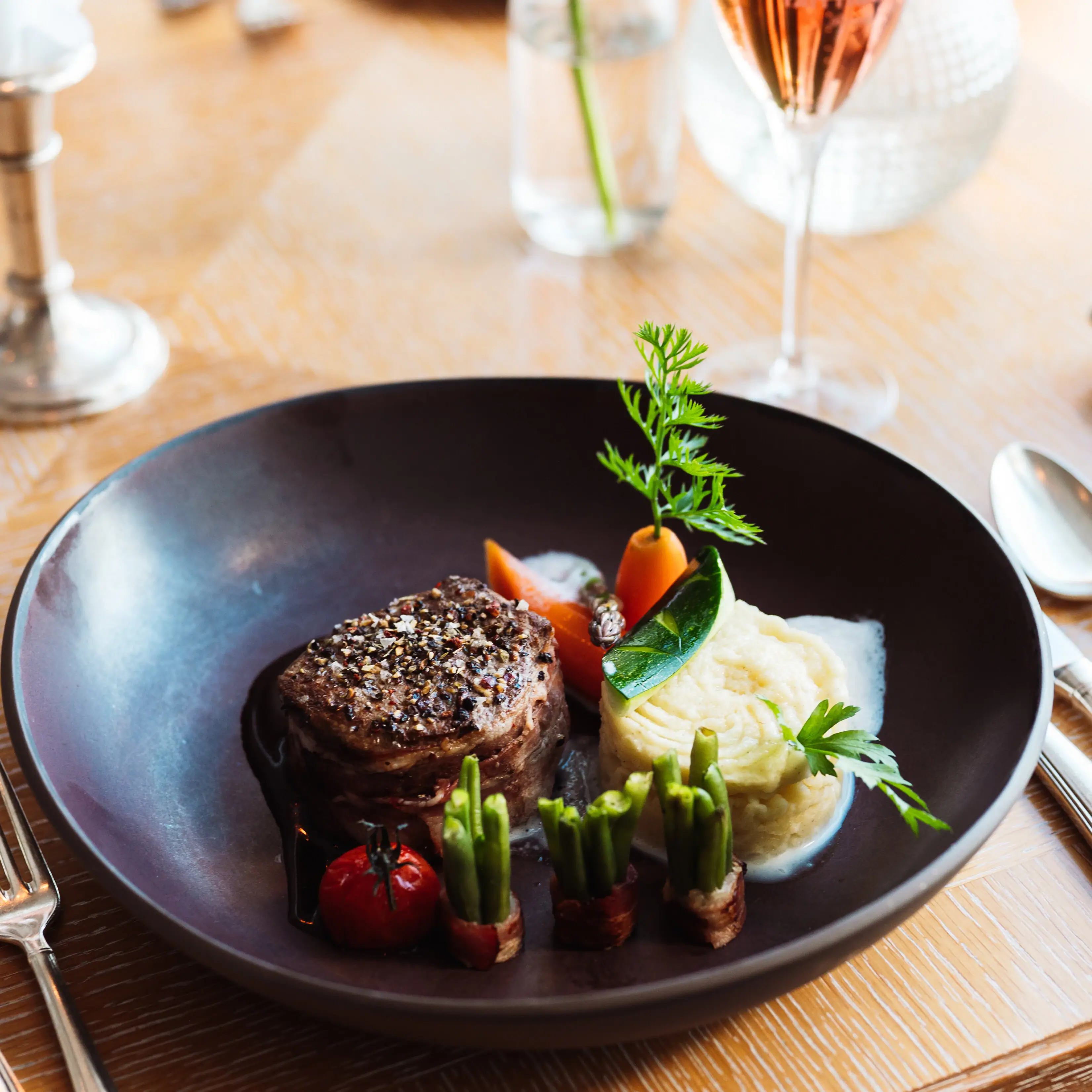Ein Teller mit kunstvoll angerichteter Speise auf einem Tisch.