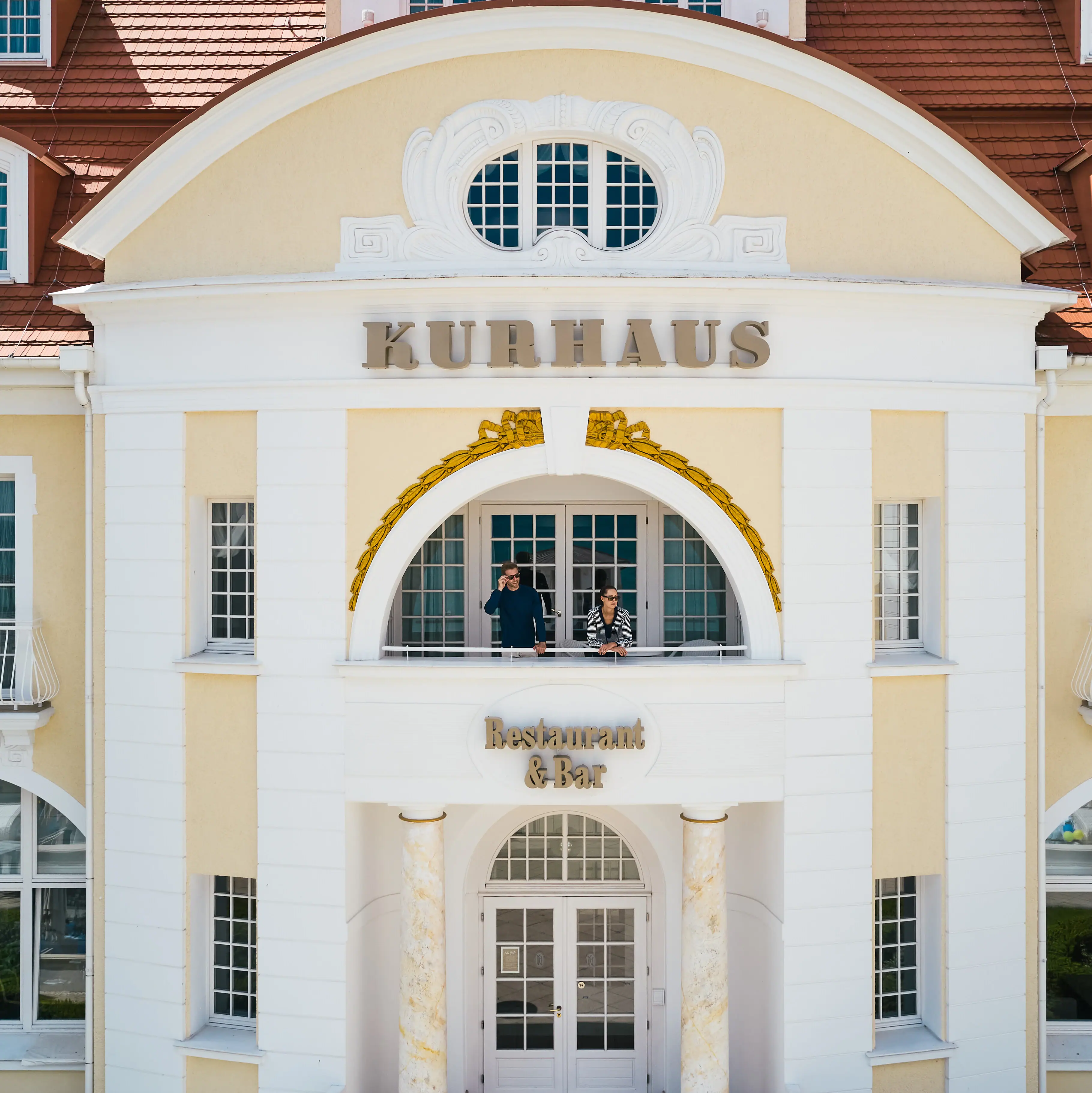 Ein Gebäude mit einem Paar, das auf dem Balkon steht.