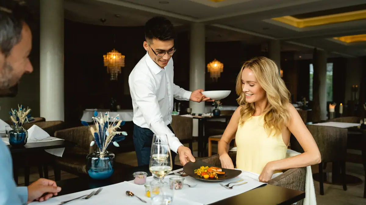 Genuss-Guthaben bei A-ROSA Kellner serviert Paar das Menü