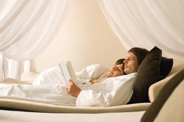 Ein Mann und eine Frau liegen auf einem Bett.