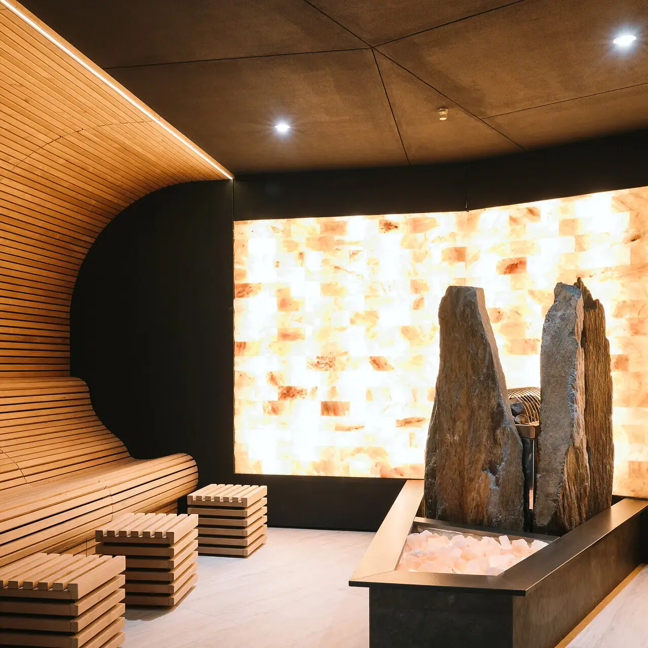 Salzsauna im A-ROSA Gardasee Eine Sauna mit Salzwand sowie mit einer Bank und Salz-Steinen.