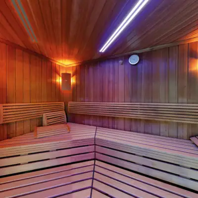 Holzsauna mit Holzwand und Leuchte