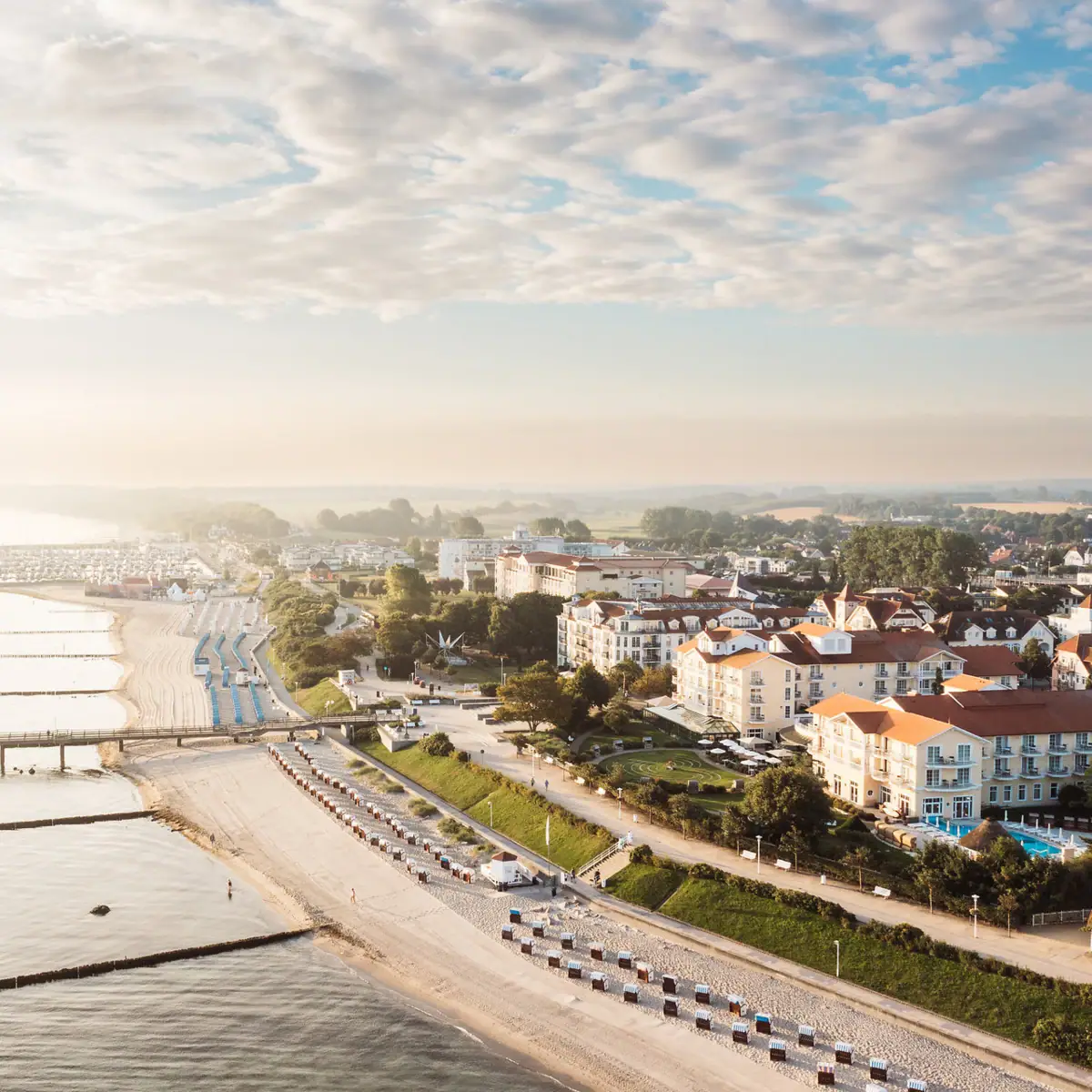 Strand mit Gebäuden und einer Brücke im Hintergrund.