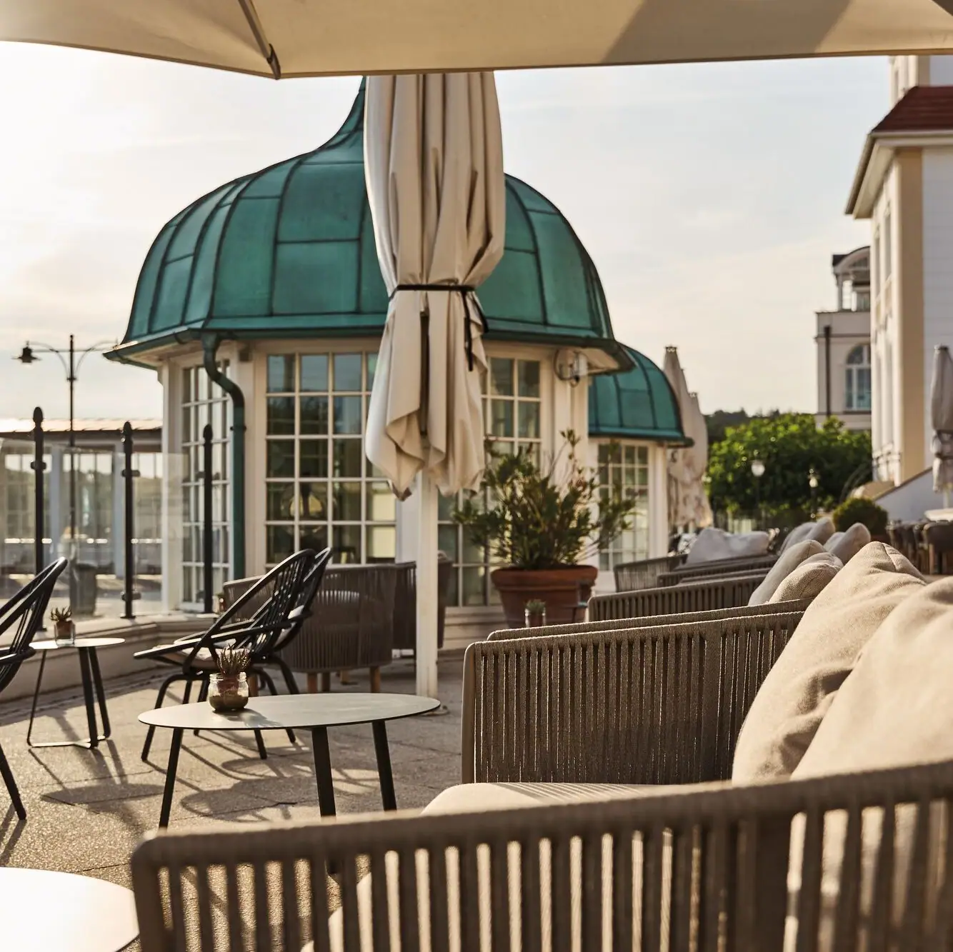 Eine Terrasse mit Stühlen und Tischen im Freien.