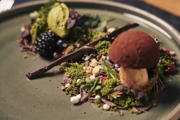 A-ROSA Gericht Ein Teller mit kunstvoll angerichteten Speisen auf einem Tisch.