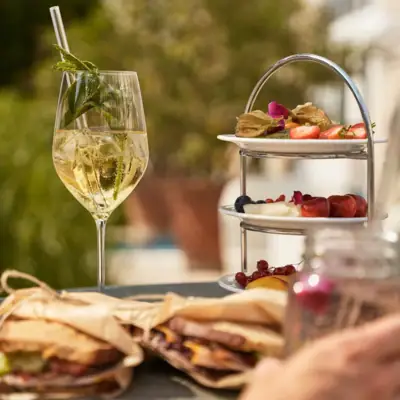 Ein Teller mit Essen auf einem Tisch, daneben ein Weinglas.