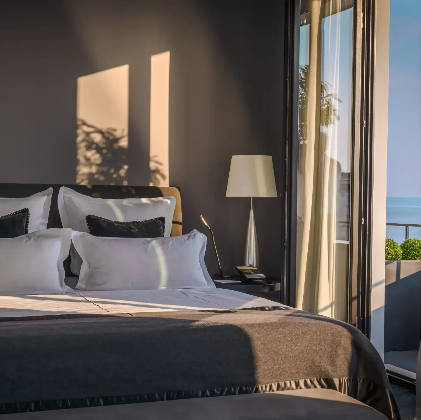 Ein Bett mit Kissen und einer Lampe in einem Zimmer.