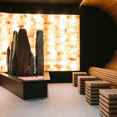 Salzsauna im A-ROSA Gardasee Ein Raum mit einer großen Felskulptur und Bänken.