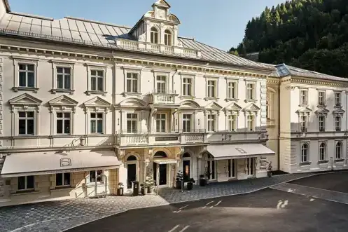 Eingang A-ROSA Bad Gastein Großes weißes Gebäude mit vielen Fenstern.