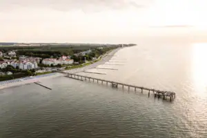 Kühlungsborn Ein langer Steg, der zu einem Strand führt.