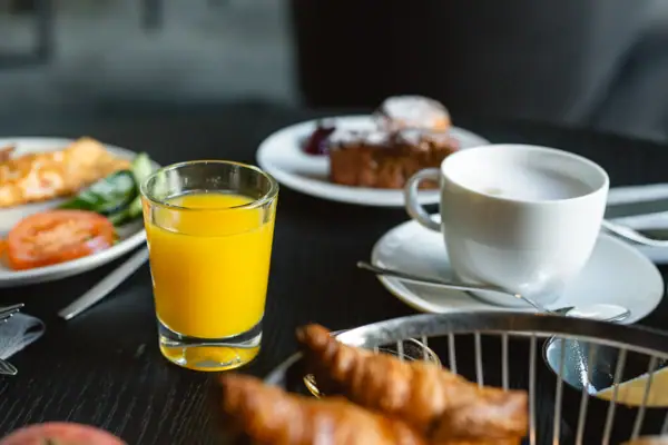 Ein Teller mit Essen und ein Glas Saft auf einem Tisch.