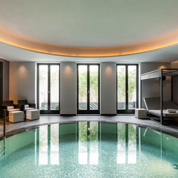 Ein Innenpool mit einem Bett und Stühlen.