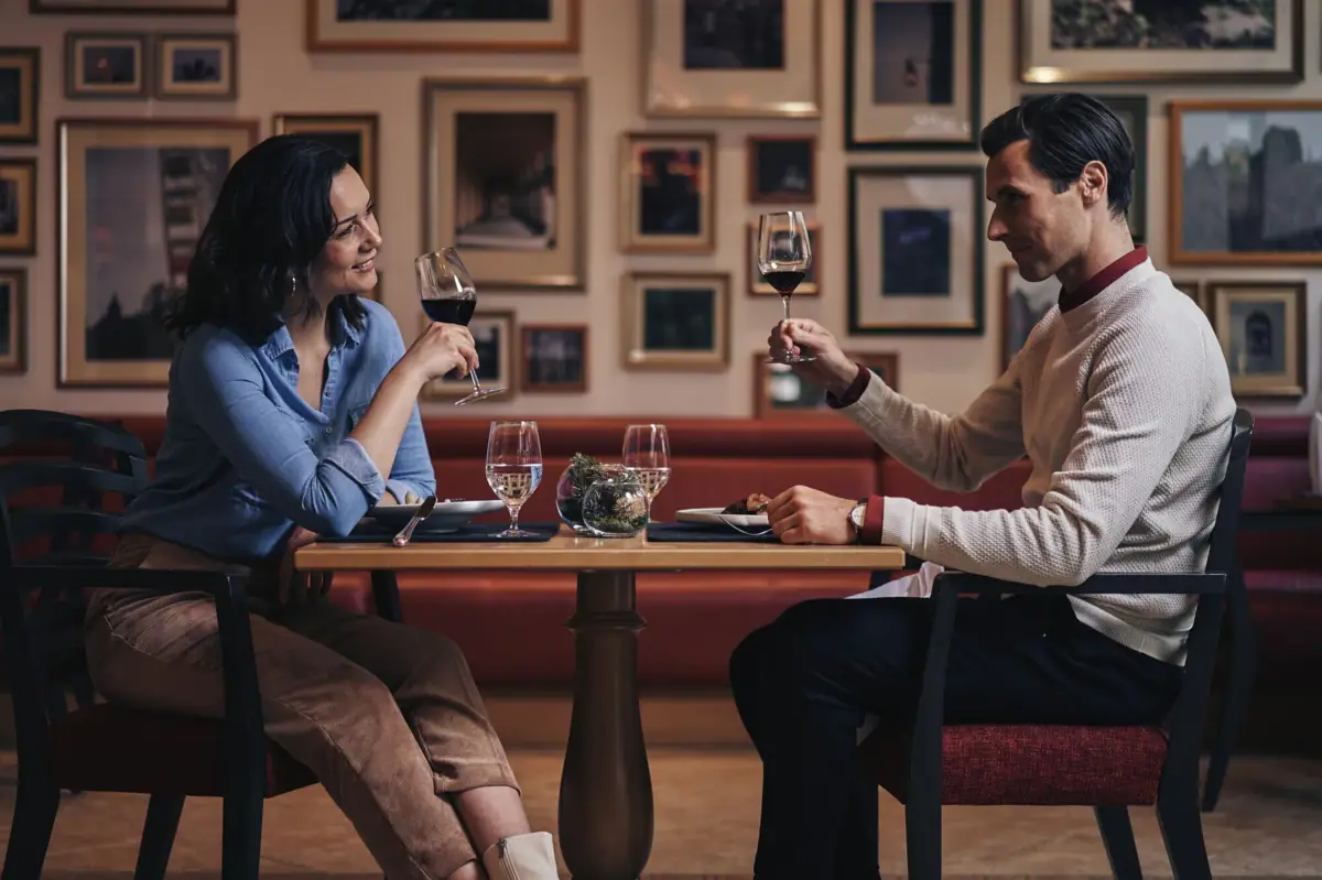 Gaststuben Gothisches Haus Ein Mann und eine Frau sitzen an einem Tisch mit Weingläsern.