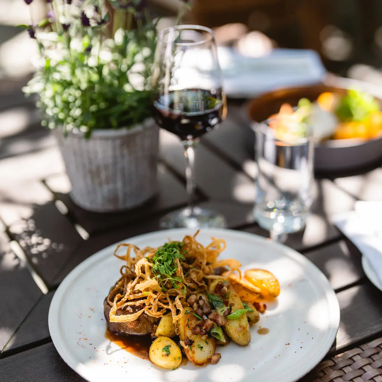 A-ROSA Travemünde Ein Teller mit Essen und ein Glas Wein.