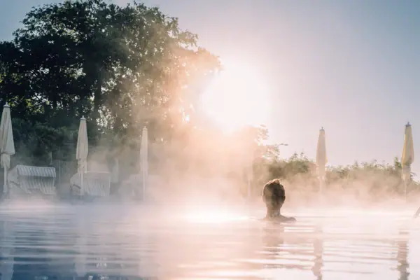 Außenpool A-ROSA Travemünde Eine Person in einem dampfenden Außenpool.