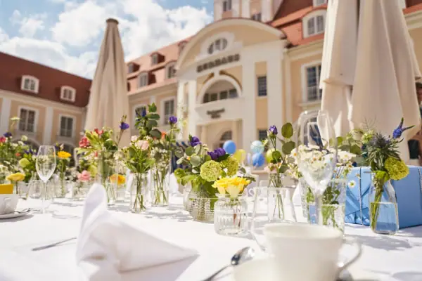 Kurhaus Binz Fest Ein für eine Feier gedeckter Tisch mit Tischgeschirr und Blumengesteck.