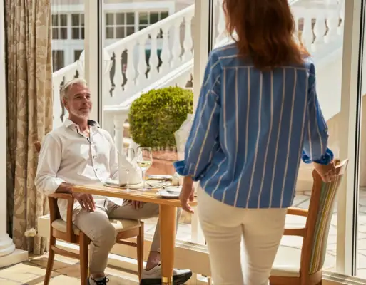 Eine Frau steht neben einem Mann an einem Tisch.