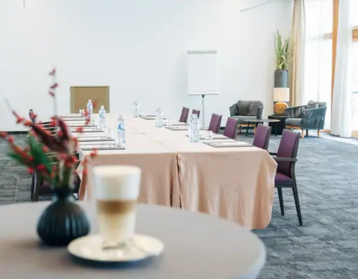 Ein Tisch mit Stühlen und einem Getränk darauf.