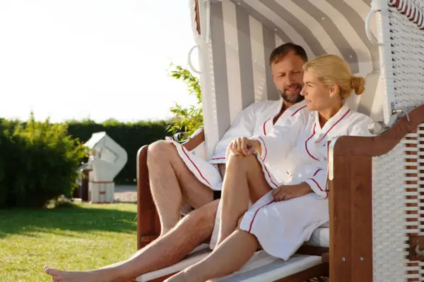 Strandkorb Travemünde Ein Mann und eine Frau sitzen in einem Stuhl im Freien.