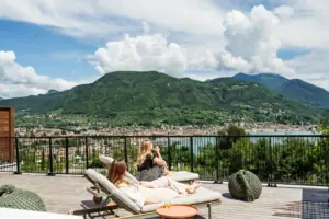 Terrasse Zwei Frauen sitzen auf einem Deck mit Blick auf ein Gewässer.