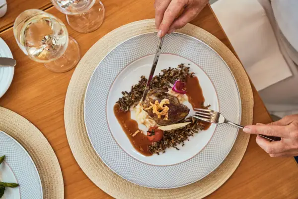 Eine Person isst eine Mahlzeit von einem Teller.